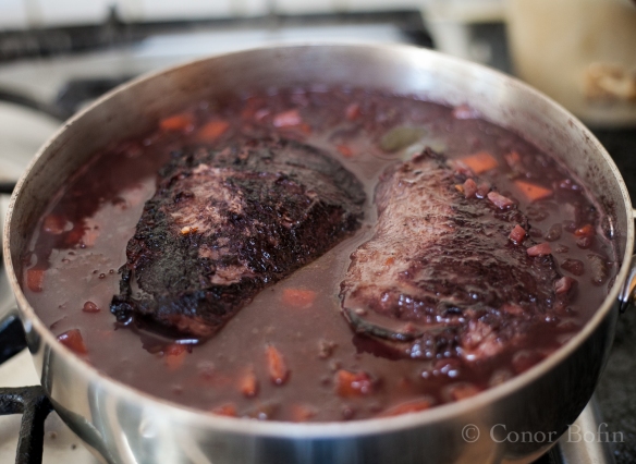 Beef cheeks back in the wine. The start of a long slow cooking.